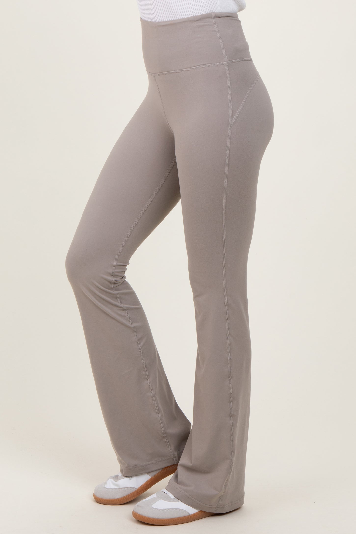 woman wearing light gray flared leggings with a high waistband