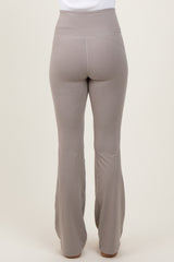 woman wearing high-waisted light brown flared leggings, view from the back