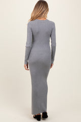 woman wearing a fitted gray ribbed maternity maxi dress with long sleeves and a sleek silhouette