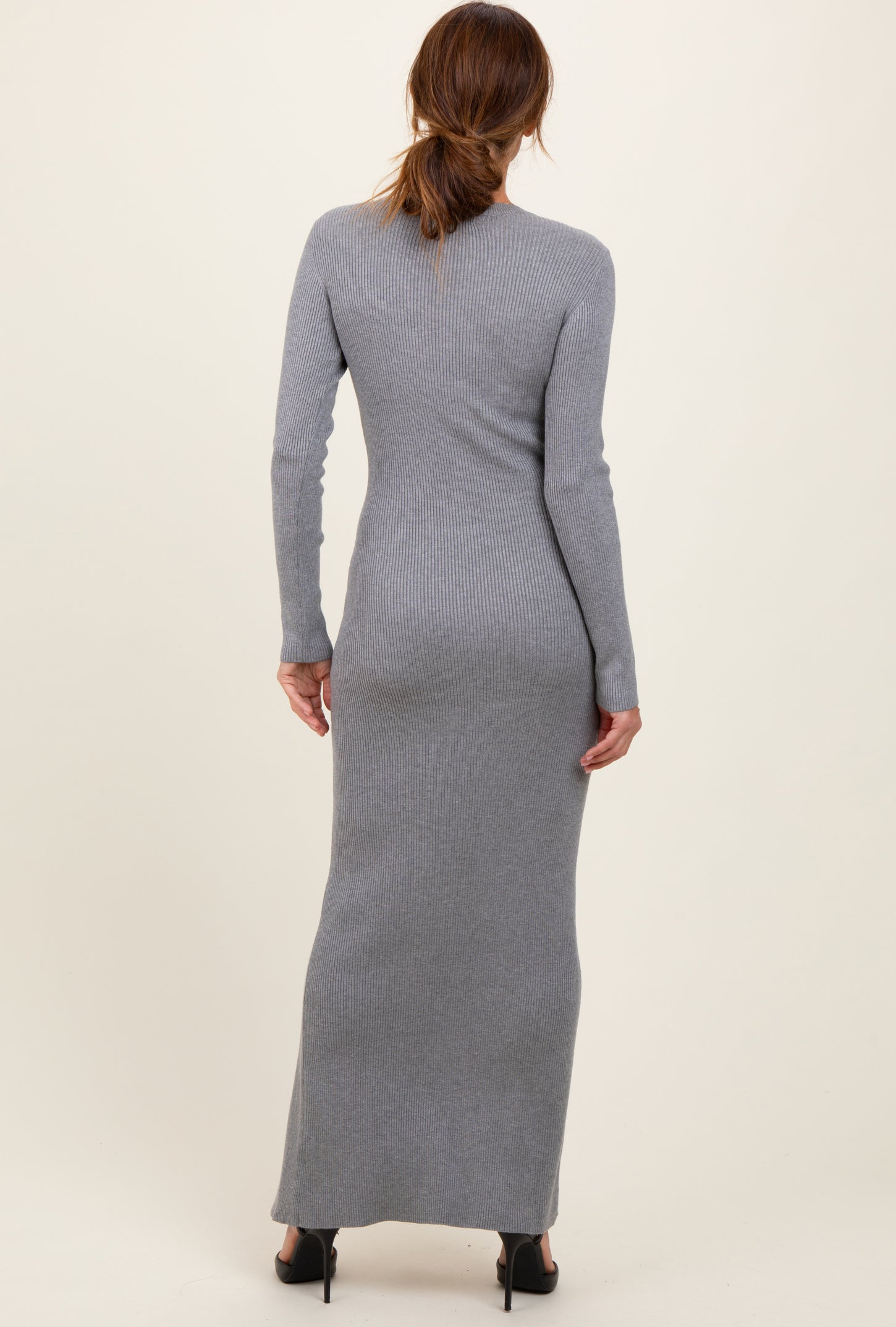 woman wearing a form-fitting gray ribbed maxi dress with long sleeves, viewed from the back