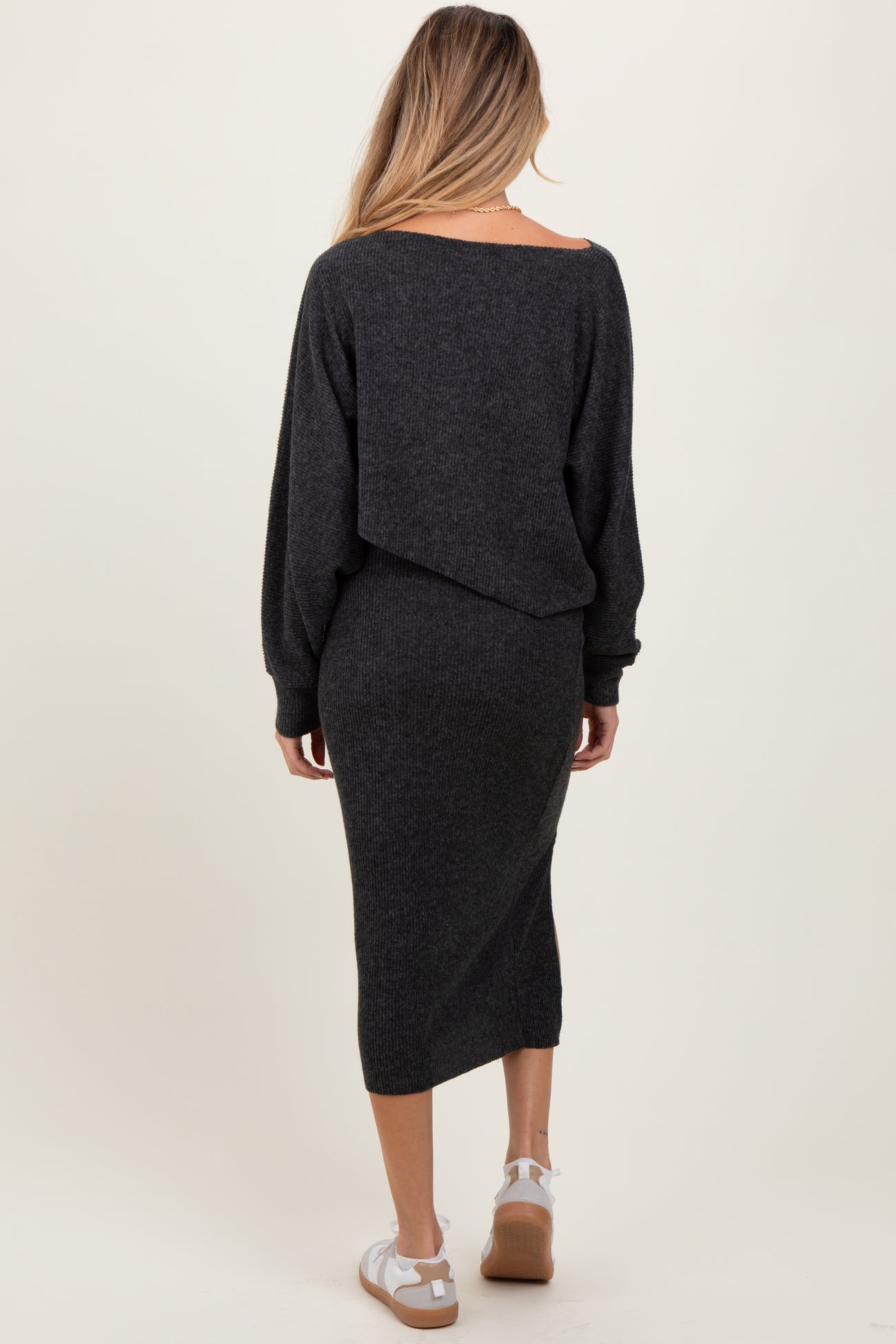 woman wearing a dark gray maternity sweater dress with an off-the-shoulder design and long sleeves