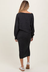 woman wearing a dark gray maternity sweater dress with an off-the-shoulder design and long sleeves