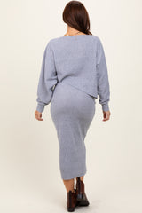 woman wearing a light blue knit cropped sweater and matching midi skirt, viewed from the back