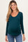 woman wearing a dark green long sleeve maternity top that hugs her baby bump