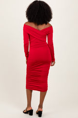 woman wearing a fitted red off-the-shoulder midi dress with ruching and long sleeves, seen from the back