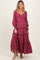 woman wearing a red floral maternity maxi dress with tiered ruffles and bell sleeves, smiling at the camera