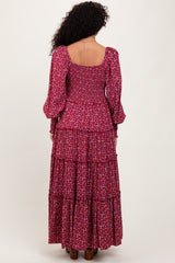 woman wearing a floral patterned long sleeve maxi dress with a smocked bodice and tiered design, viewed from the back