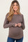 woman wearing a brown long sleeve maternity top with a relaxed fit and visible baby bump