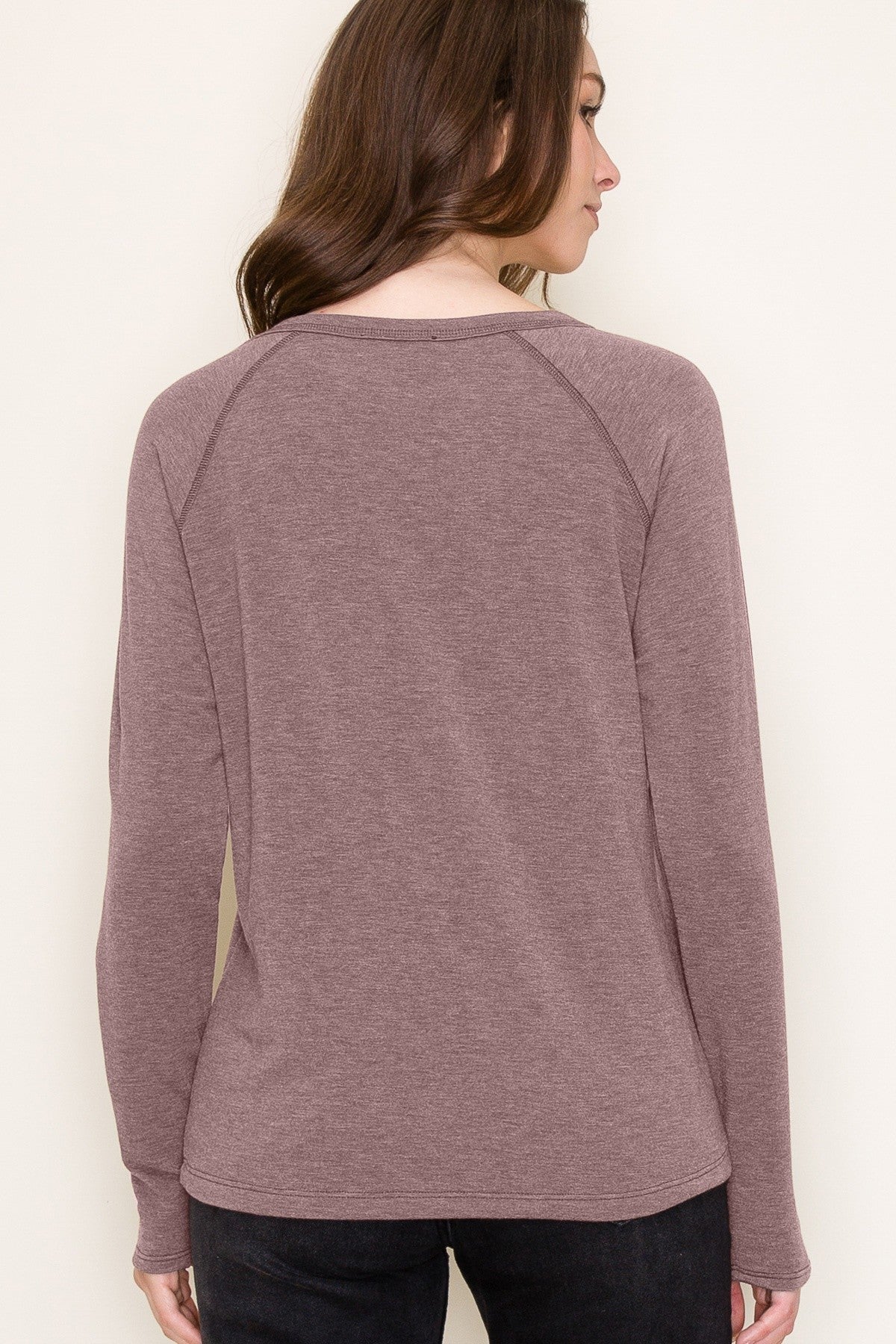 woman wearing a mauve long sleeve top with a relaxed fit and raglan sleeves, viewed from the back