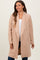 woman wearing a blush pink maternity coat with an open front and long sleeves
