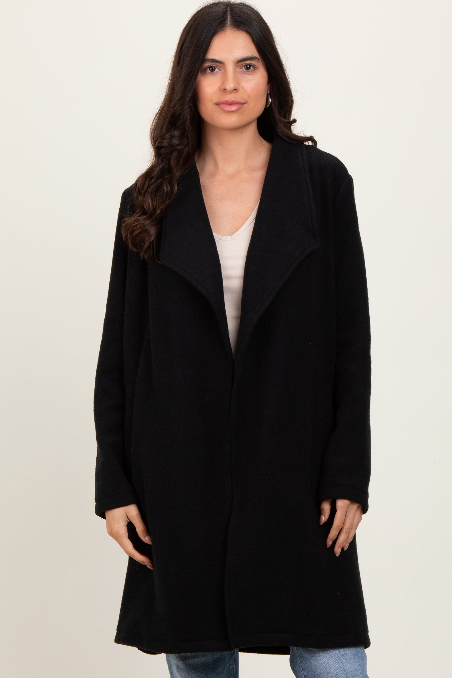 woman wearing a black long sleeve oversized coat with a shawl collar and open front