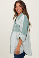 woman wearing a green and white striped maternity shirt with a front pocket and a relaxed fit, showing a baby bump