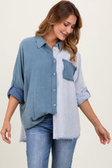 woman wearing a blue and white striped oversized button-up shirt with a chest pocket and rolled sleeves