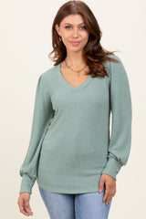 woman wearing a mint green long sleeve ribbed v-neck top with balloon sleeves and a relaxed fit