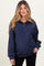 woman wearing a navy blue maternity pullover sweater with a collar and button detail, holding her baby bump