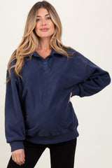 woman wearing a navy blue cozy maternity sweatshirt with a button placket and relaxed fit, showing her baby bump