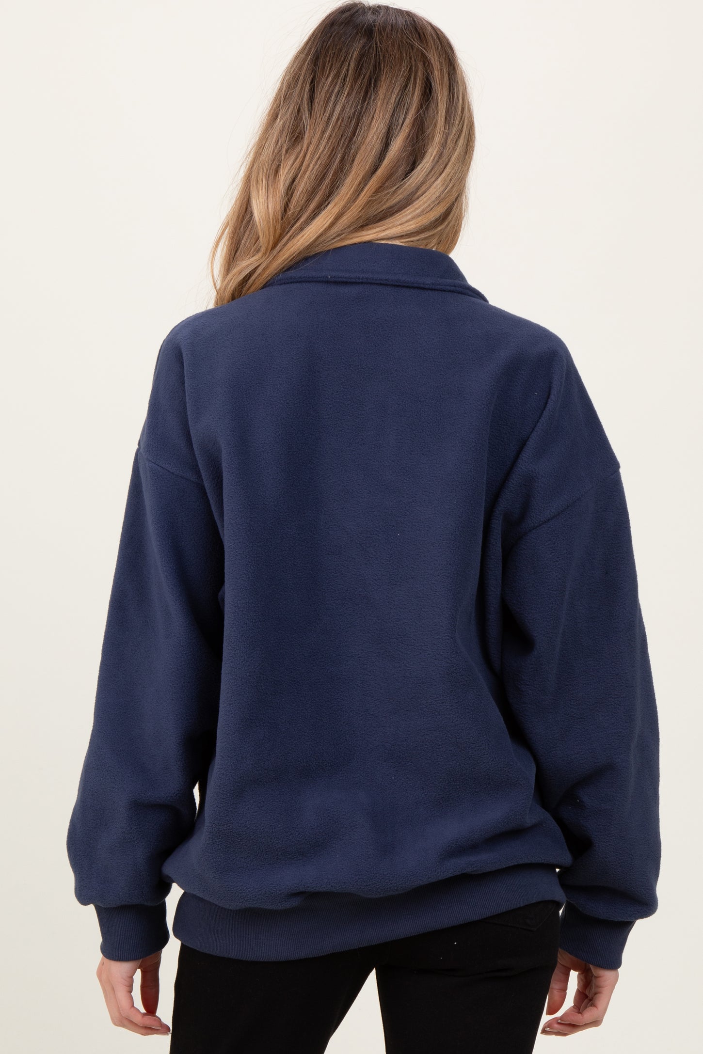 woman wearing a navy blue maternity fleece sweater seen from the back