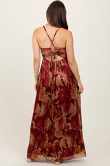 woman wearing a burgundy floral maternity maxi dress with a crisscross back design and gathered waist