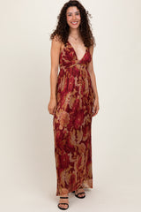 woman wearing a red floral maxi dress with a plunging neckline and gathered waist