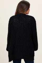 woman wearing a black open-knit maternity cardigan, seen from the back