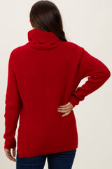 woman wearing a red maternity sweater with a turtle neck and ribbed texture, viewed from the back