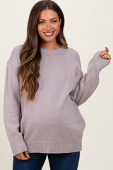 woman wearing a light purple oversized maternity sweater with a relaxed fit and ribbed cuffs, displaying her baby bump