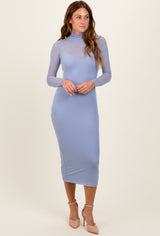 woman wearing a light blue long sleeve bodycon midi dress with a sheer neckline and fitted silhouette