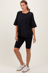 woman wearing a black oversized t-shirt with pocket and black bike shorts, paired with white sneakers