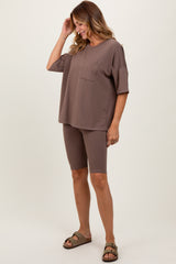 woman wearing a brown oversized t-shirt with pocket and matching bike shorts, styled with comfortable sandals