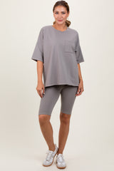 woman wearing a loose-fitting grey short sleeve t-shirt with a pocket and matching grey biker shorts