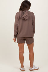 woman wearing a brown maternity hoodie and matching shorts, showing a comfortable casual style from the back
