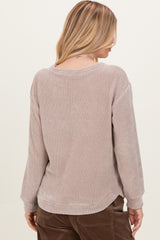 woman wearing a beige waffle knit long sleeve top, showing the back view and relaxed fit