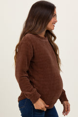 woman wearing a brown ribbed maternity sweater and showing her baby bump