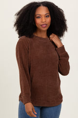 woman wearing a brown ribbed knit long sleeve sweater with a round neckline and relaxed fit
