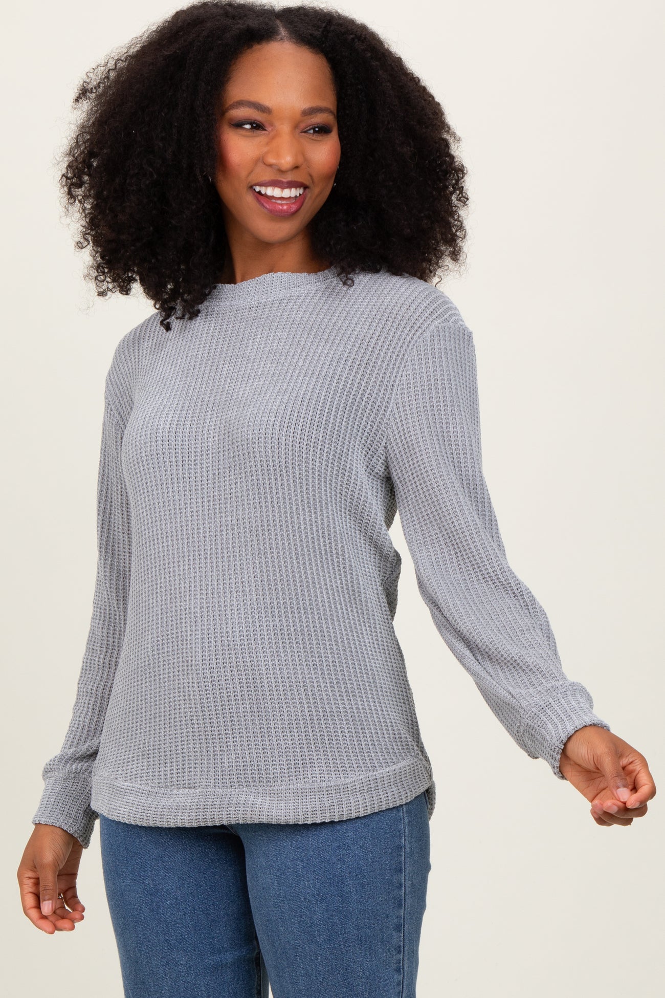 woman wearing a gray long sleeve textured sweater with a relaxed fit and a round neckline