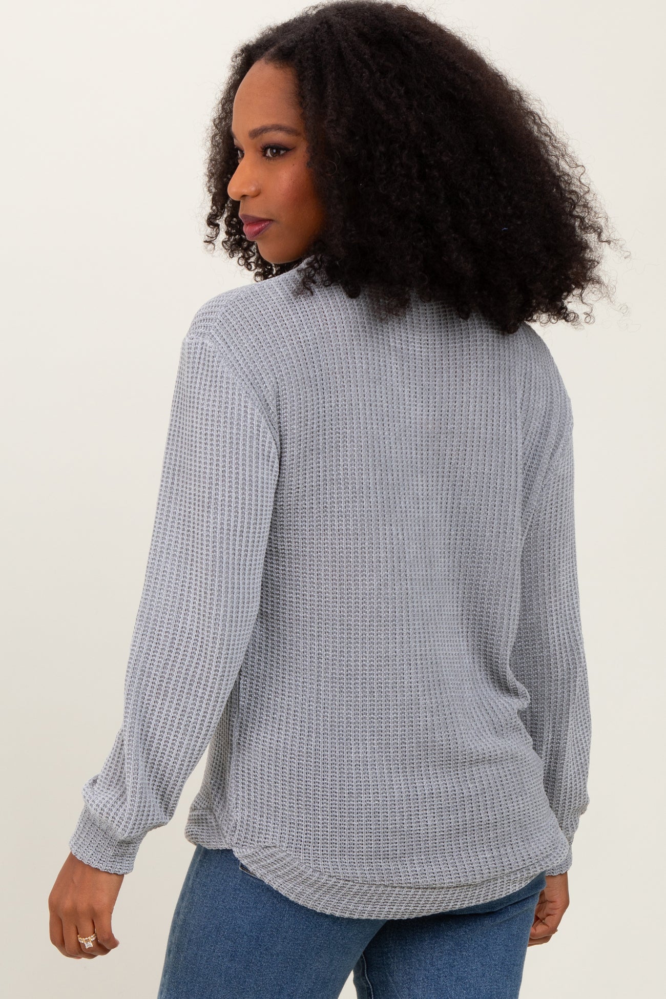 woman wearing a gray long sleeve textured knit top with a relaxed fit and casual style