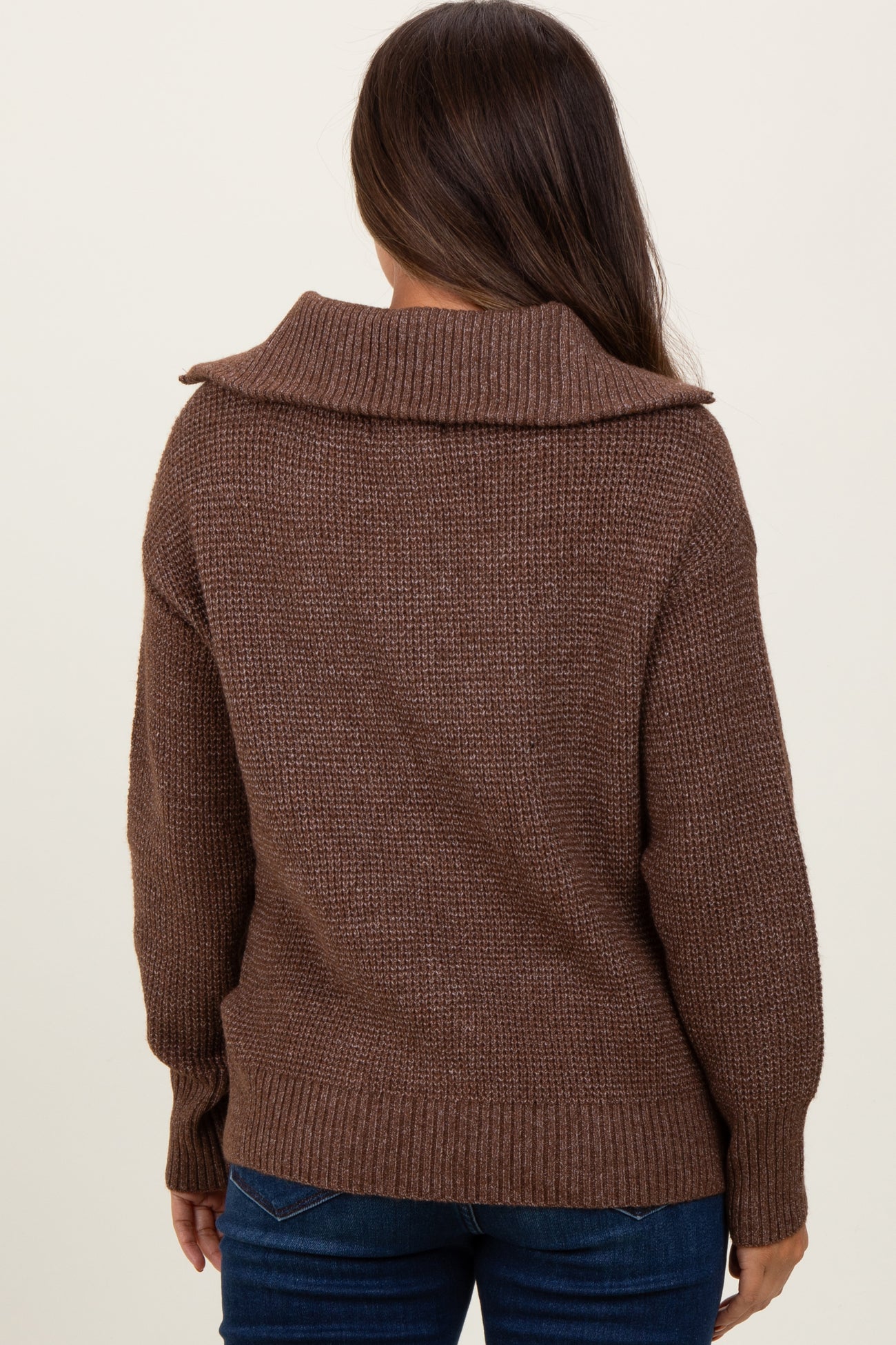 woman wearing a brown oversized maternity sweater with a cozy collar, viewed from the back