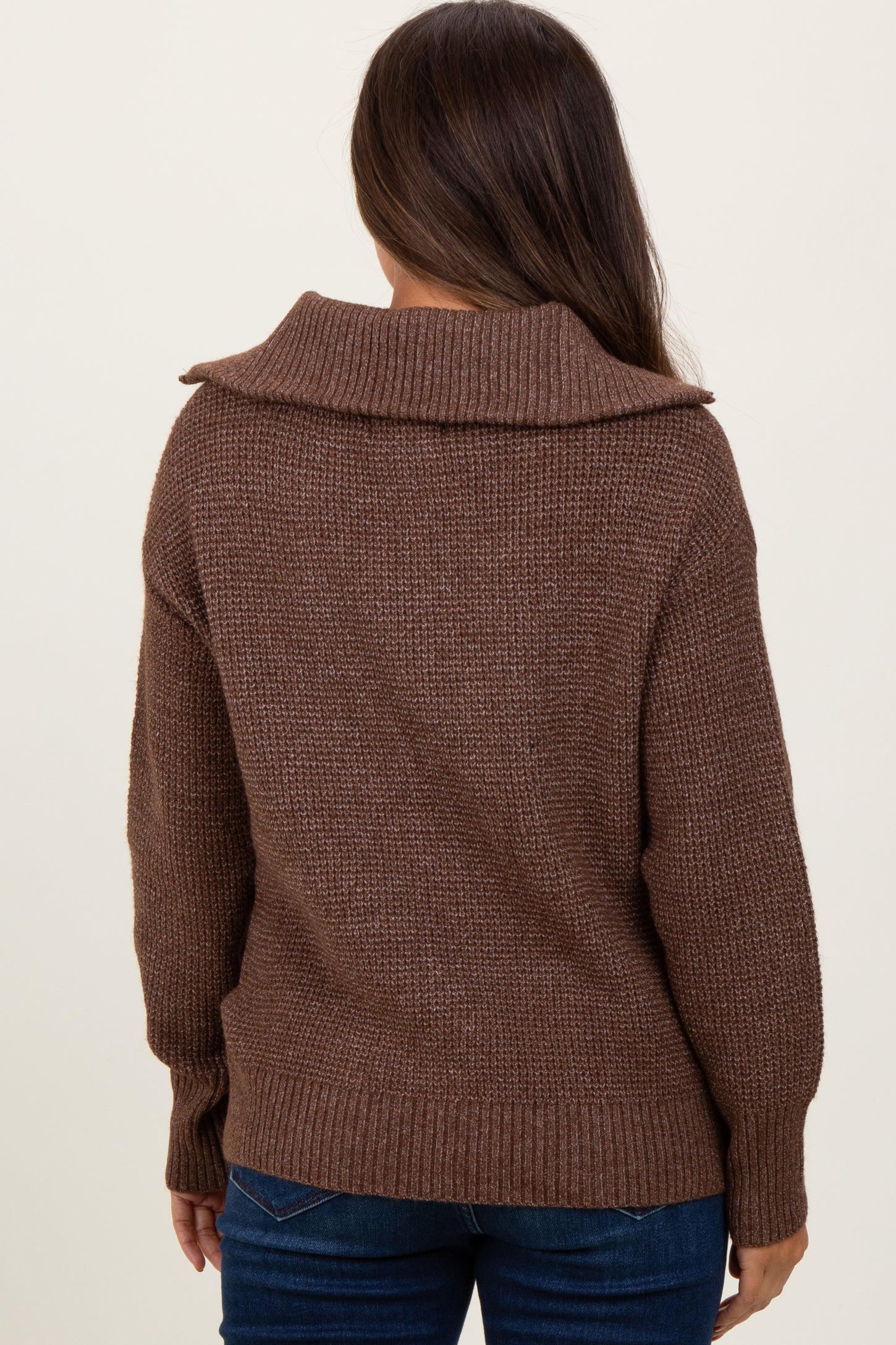 woman wearing a brown oversized maternity sweater with a cozy collar, viewed from the back