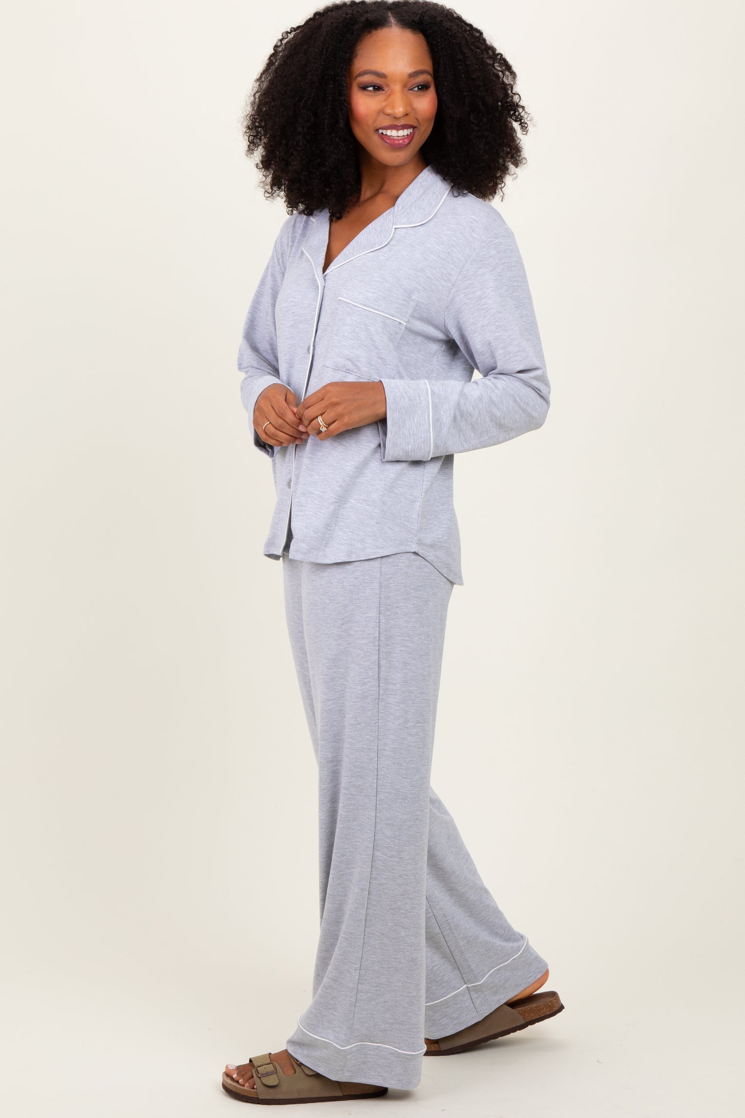 woman wearing a grey long sleeve pajama set with a button-up top and wide-leg pants