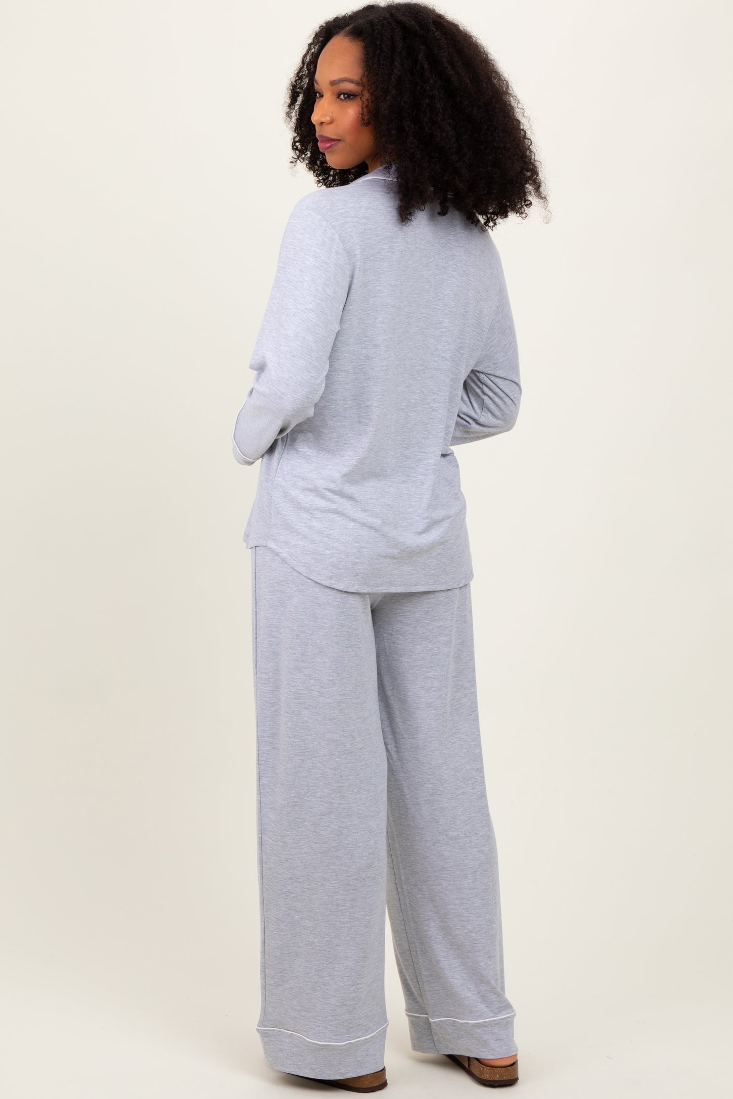 woman wearing a gray long sleeve top and matching wide-leg pants, viewed from the back