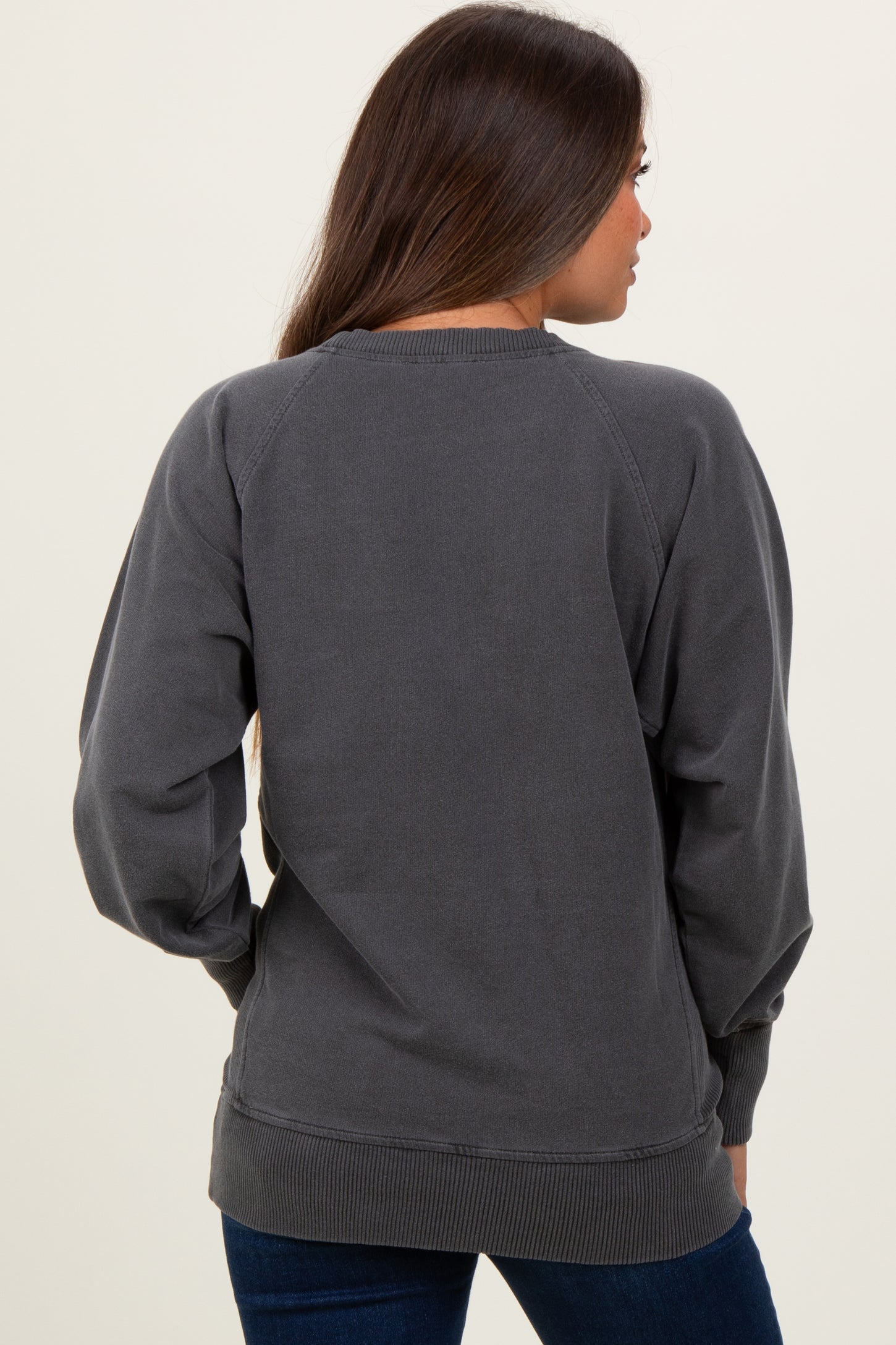 woman wearing a dark gray maternity sweatshirt with raglan sleeves, viewed from the back