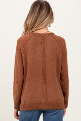 woman wearing a burnt orange maternity sweater with a textured finish and a relaxed fit, shown from the back