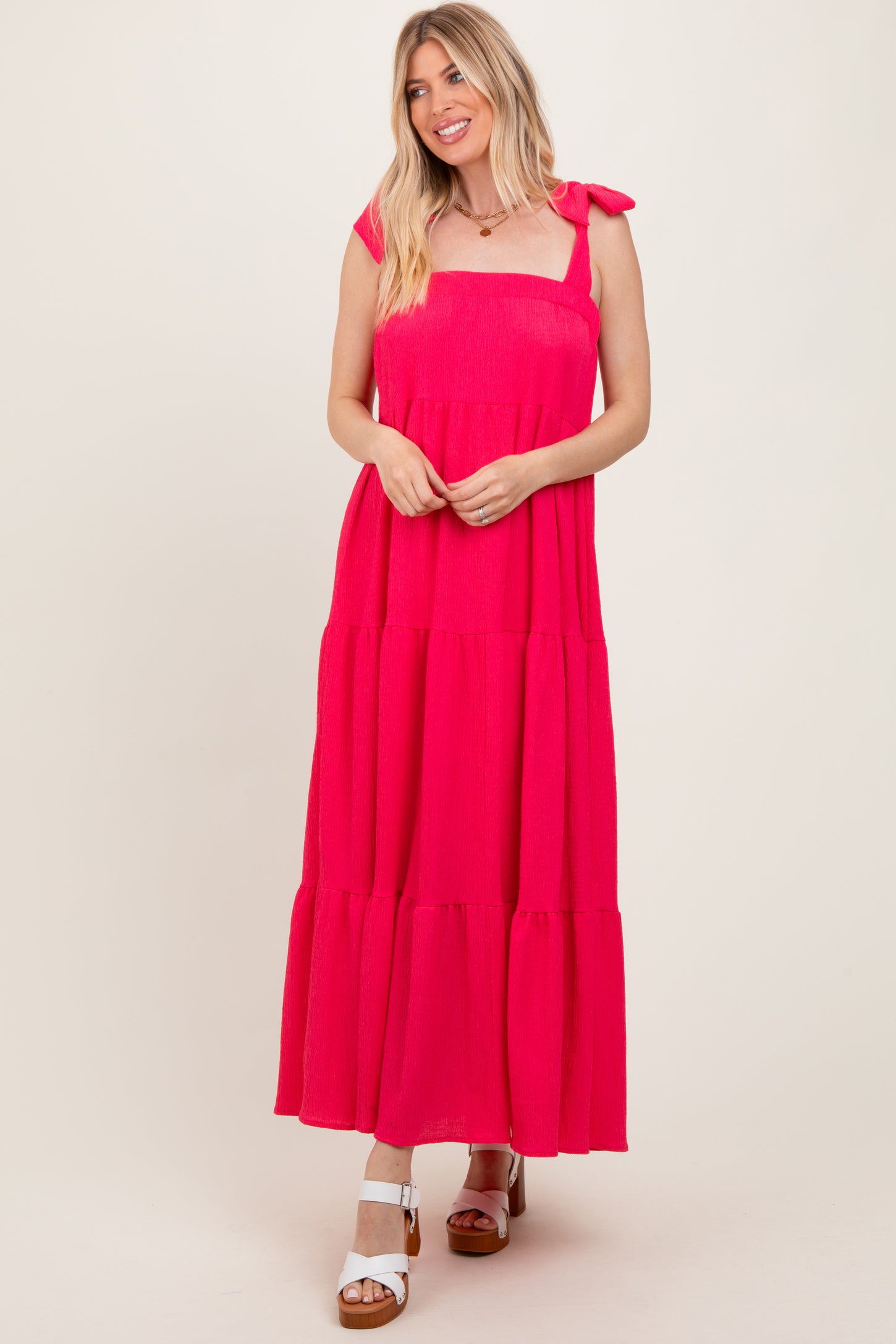 woman wearing a hot pink tiered maxi dress with tie straps and a relaxed fit