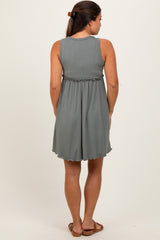 woman wearing a grey ribbed maternity dress with a gathered waist and a flared skirt, seen from the back