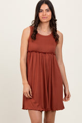 woman wearing a rust-colored pleated sundress with a fitted waist and flared skirt