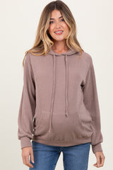 woman wearing a ribbed brown maternity hoodie with a front pocket and drawstring hood, showcasing a visible baby bump