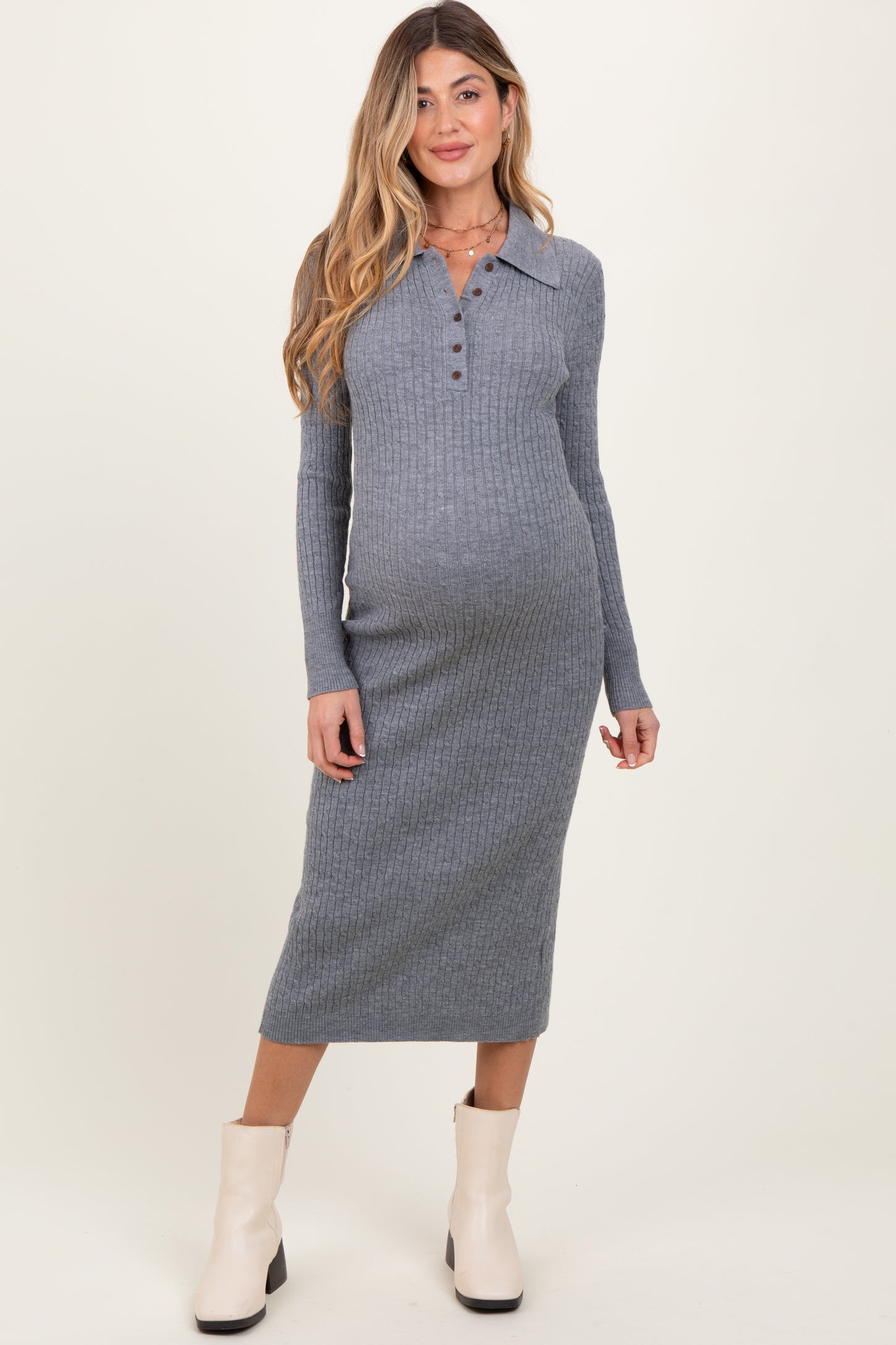 woman wearing a ribbed gray long sleeve maternity dress with a collar and button detail, showing her baby bump