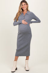 woman wearing a grey ribbed midi maternity dress with a collar and buttons, holding her baby bump