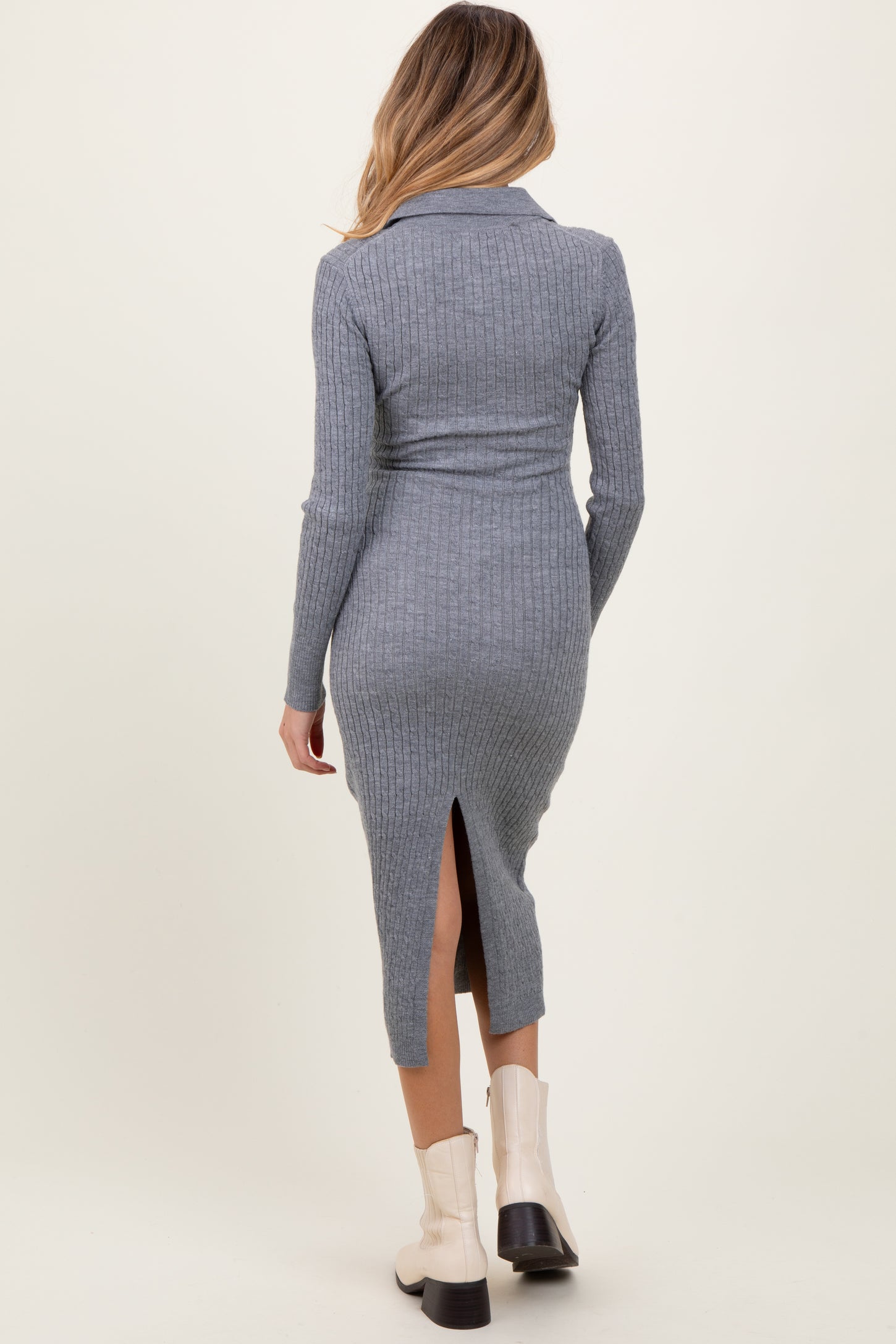woman wearing a grey ribbed maternity dress with a back slit and long sleeves