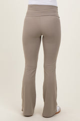 woman wearing light brown maternity flared leggings, showing the back view